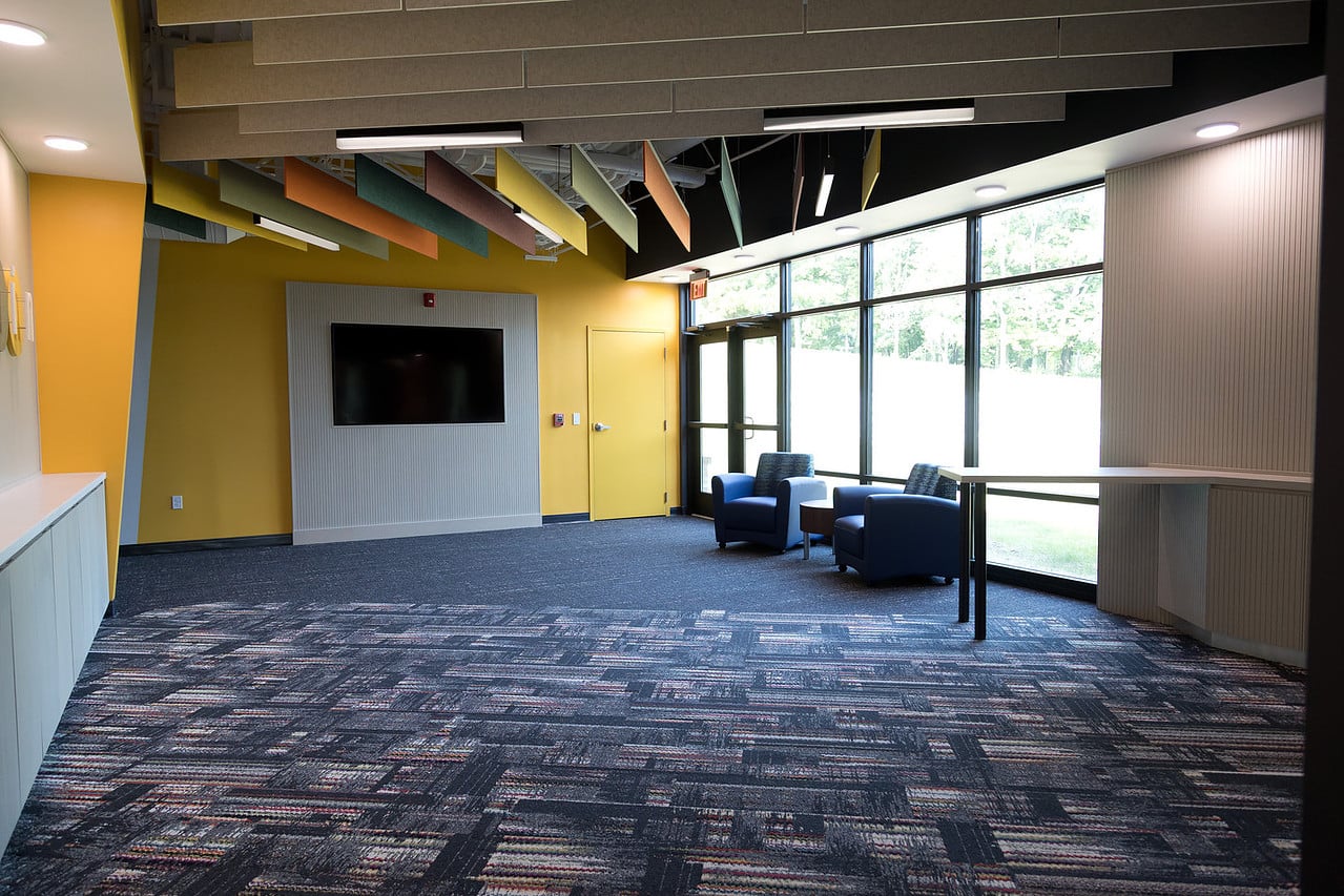 Finished interior with suspended acoustical ceiling baffles, linear lighting, and colorful wall finishes